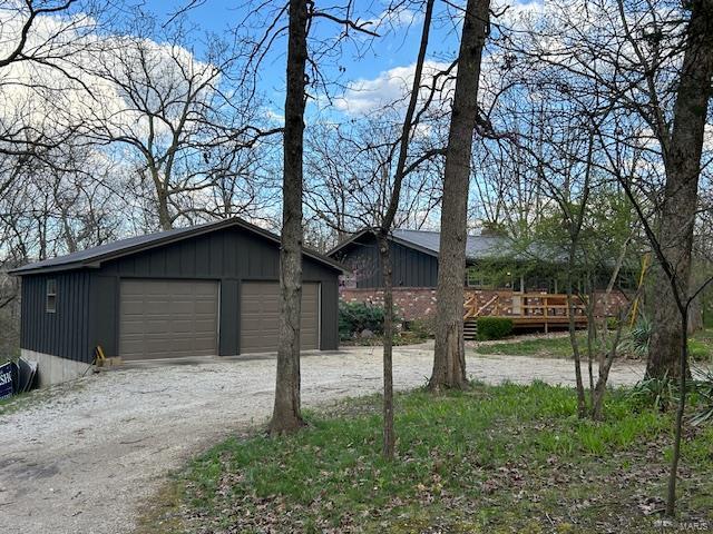 exterior space featuring an outbuilding, a deck, and a garage