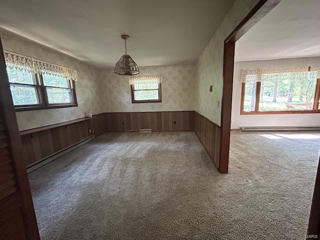 carpeted spare room featuring baseboard heating