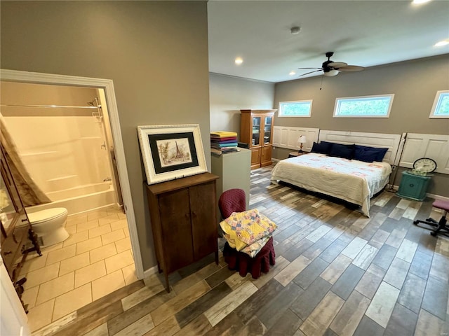 bedroom with ensuite bath, ceiling fan, and hardwood / wood-style floors