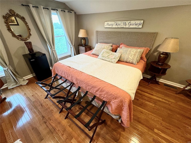 bedroom with hardwood / wood-style floors and vaulted ceiling