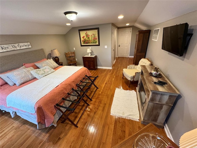 bedroom with hardwood / wood-style flooring and vaulted ceiling