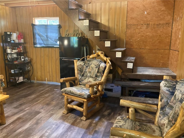 sitting room featuring wood-type flooring and wooden walls