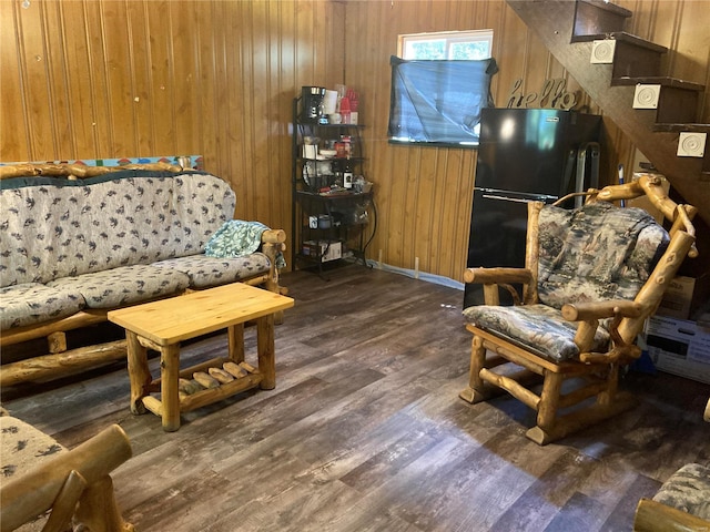 living room with dark wood-type flooring and wooden walls