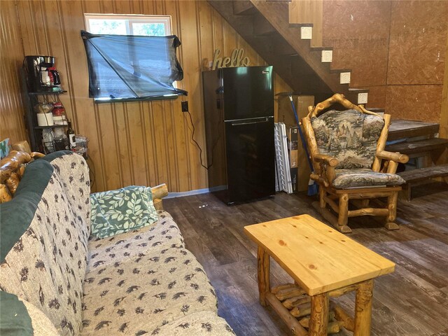 living room with dark wood-type flooring and wood walls