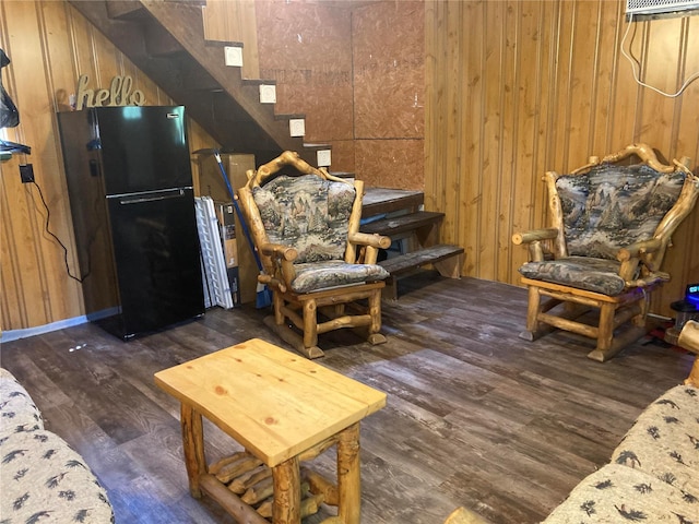 living room with wood walls and dark wood-type flooring