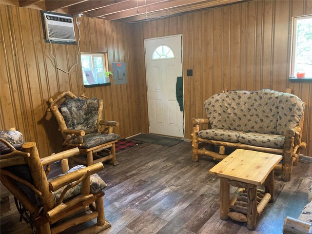 sitting room with wood walls, dark wood-type flooring, and a wall mounted AC