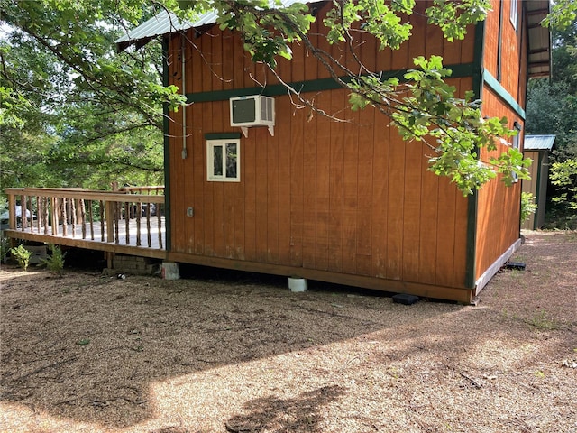 view of property exterior featuring a wall mounted AC and a deck