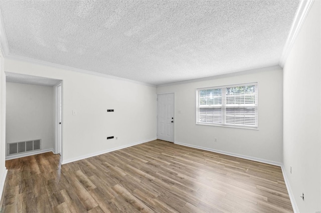 spare room with crown molding, a textured ceiling, and hardwood / wood-style flooring