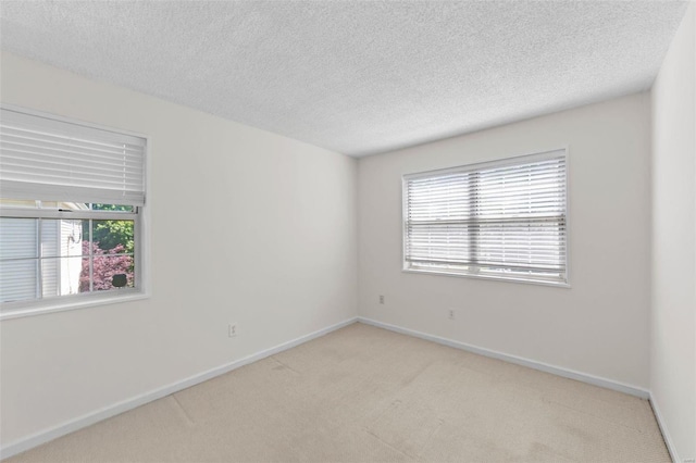 carpeted spare room with a textured ceiling