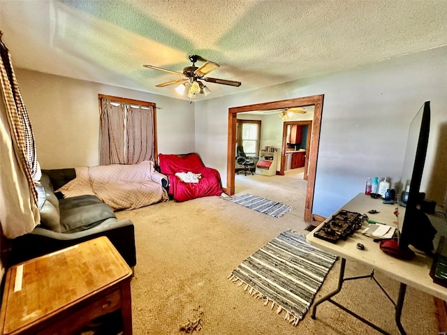 carpeted bedroom with ceiling fan and a textured ceiling