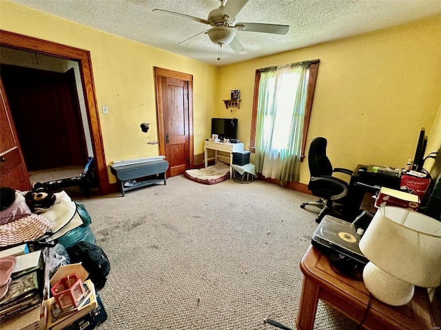 carpeted office featuring ceiling fan and a textured ceiling