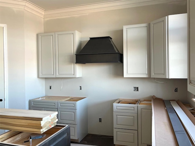 kitchen with gray cabinets, crown molding, and custom range hood