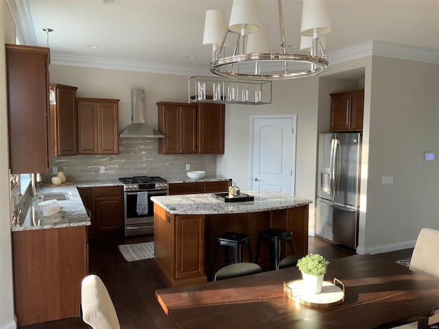 kitchen with stainless steel appliances, crown molding, dark wood-type flooring, wall chimney range hood, and a kitchen island