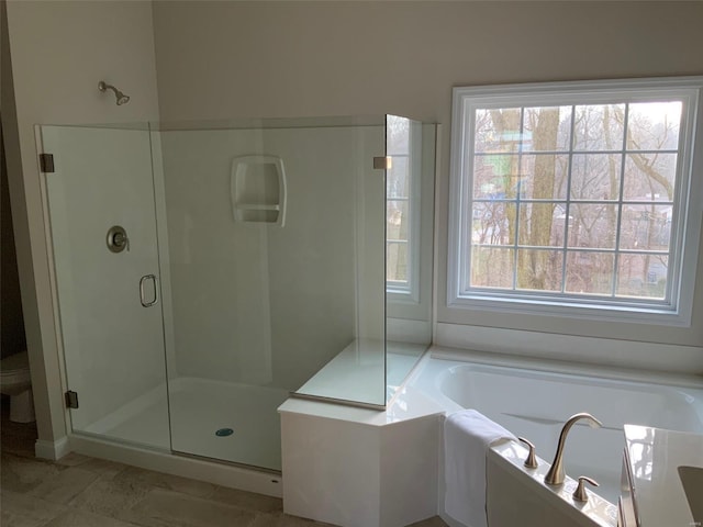 bathroom with a wealth of natural light and independent shower and bath