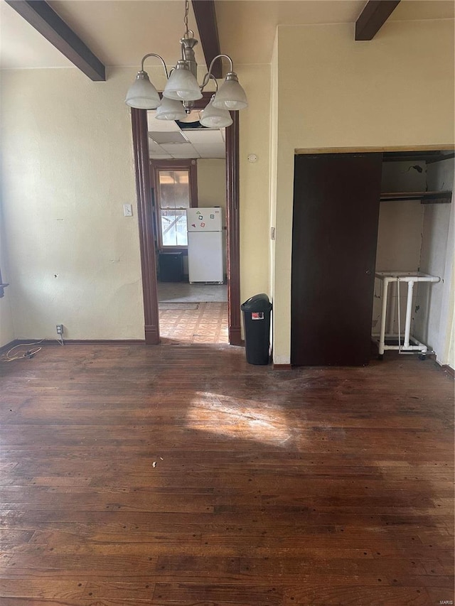 unfurnished dining area with dark hardwood / wood-style flooring, beamed ceiling, and a notable chandelier