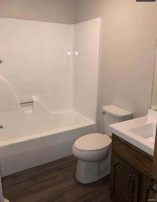 full bathroom featuring washtub / shower combination, hardwood / wood-style flooring, toilet, and vanity