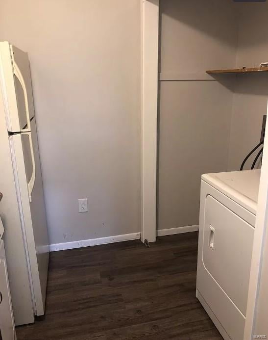 laundry area with dark hardwood / wood-style floors and washer / dryer