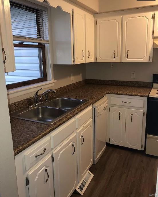 kitchen featuring stove, white cabinetry, white dishwasher, dark wood-type flooring, and sink