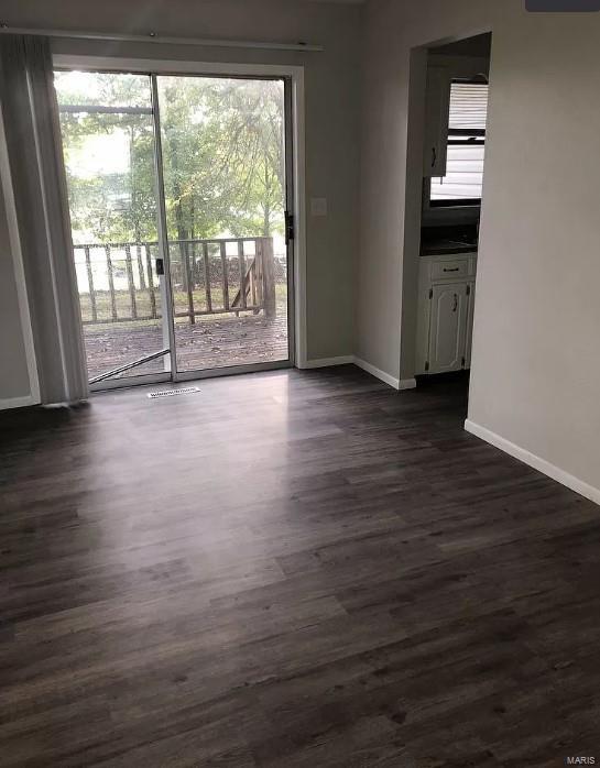 unfurnished room with dark wood-type flooring