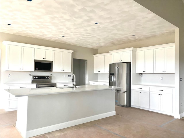 kitchen with stainless steel appliances, a kitchen island with sink, sink, and white cabinets