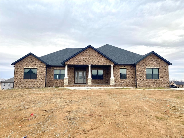 craftsman inspired home with brick siding and roof with shingles