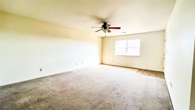 carpeted spare room featuring ceiling fan