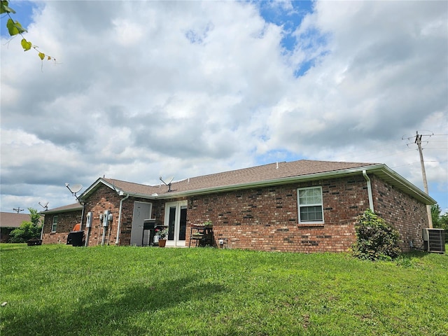 rear view of house featuring a yard and central AC unit