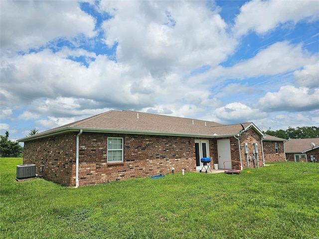 rear view of property featuring a patio, central AC unit, and a yard