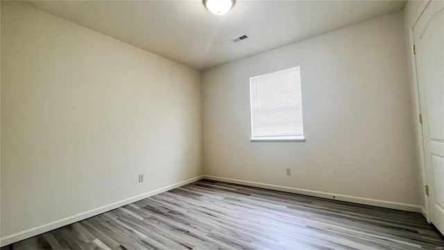 unfurnished room with hardwood / wood-style flooring