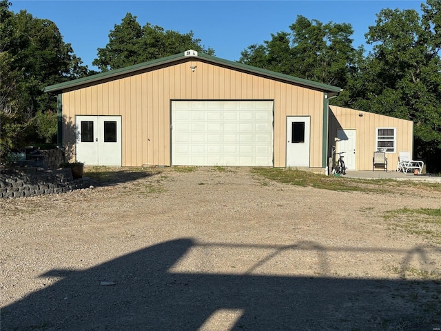 detached garage featuring dirt driveway