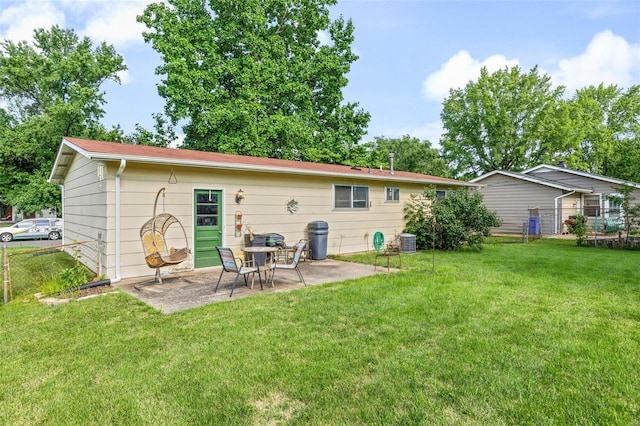 rear view of property with a lawn, a patio area, and central air condition unit