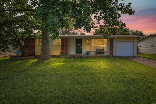 ranch-style home featuring a lawn, a porch, and a garage