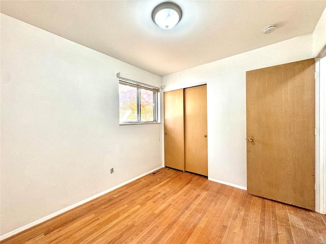 unfurnished bedroom with light hardwood / wood-style floors and a closet