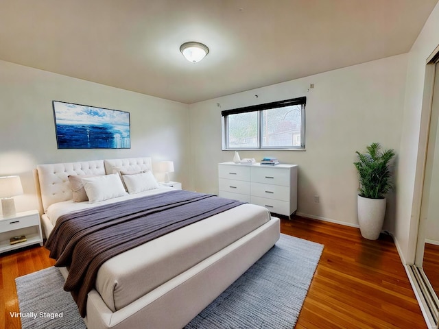 bedroom with hardwood / wood-style floors and a baseboard radiator