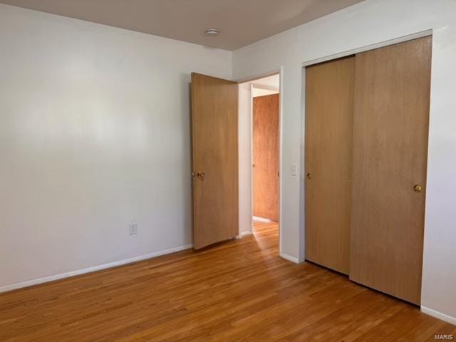 unfurnished bedroom featuring a closet and light wood-type flooring