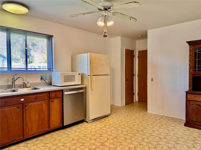 kitchen featuring ceiling fan, decorative backsplash, white appliances, and sink