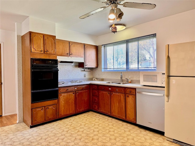 kitchen with decorative backsplash, light wood-type flooring, white appliances, ceiling fan, and sink