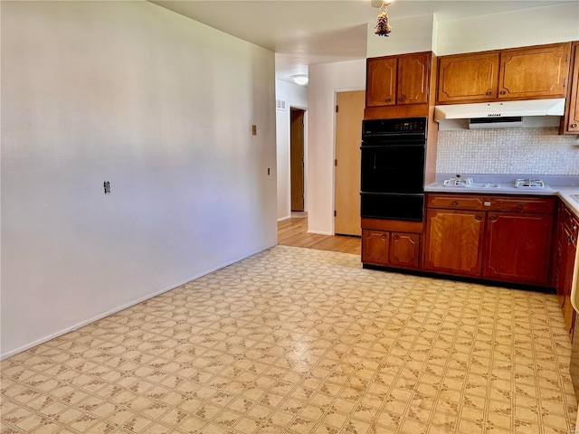 kitchen with light hardwood / wood-style floors, white gas cooktop, and backsplash