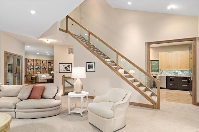 living room featuring light colored carpet and high vaulted ceiling