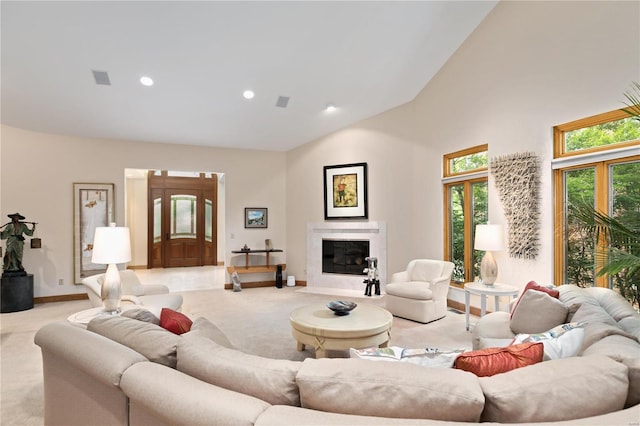 living room featuring high vaulted ceiling, a fireplace, and light carpet