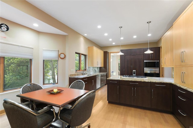 kitchen with light wood-type flooring, dark brown cabinets, sink, pendant lighting, and built in appliances