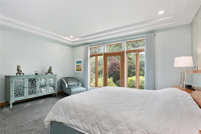 carpeted bedroom with a tray ceiling and french doors