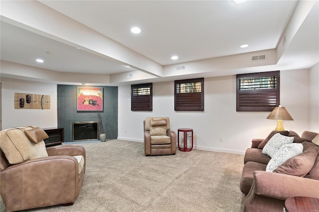 living room with a fireplace and light colored carpet