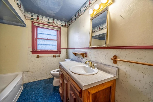 bathroom with a bathtub, vanity, and toilet