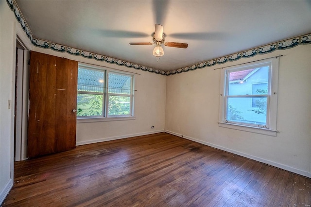 spare room with a ceiling fan, baseboards, and wood finished floors