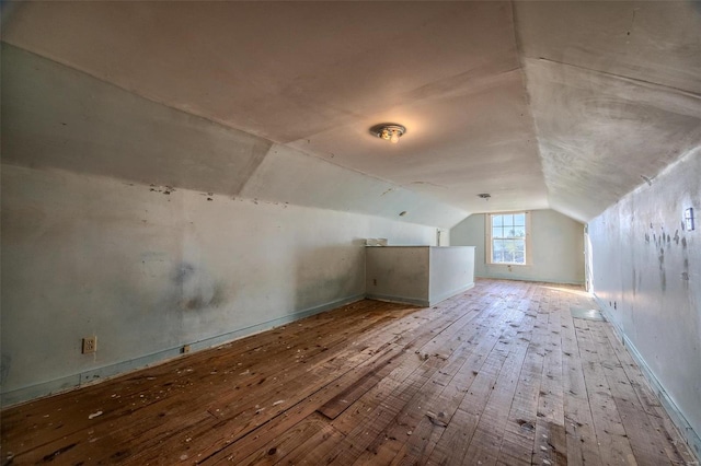 additional living space featuring lofted ceiling and hardwood / wood-style flooring