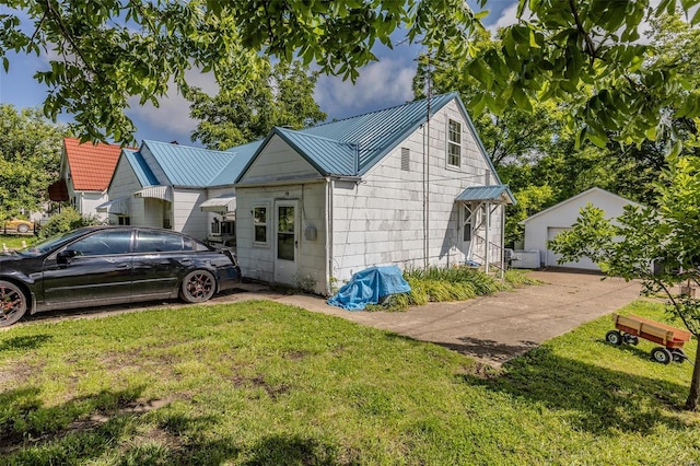 exterior space with an outbuilding, a yard, a standing seam roof, metal roof, and a garage