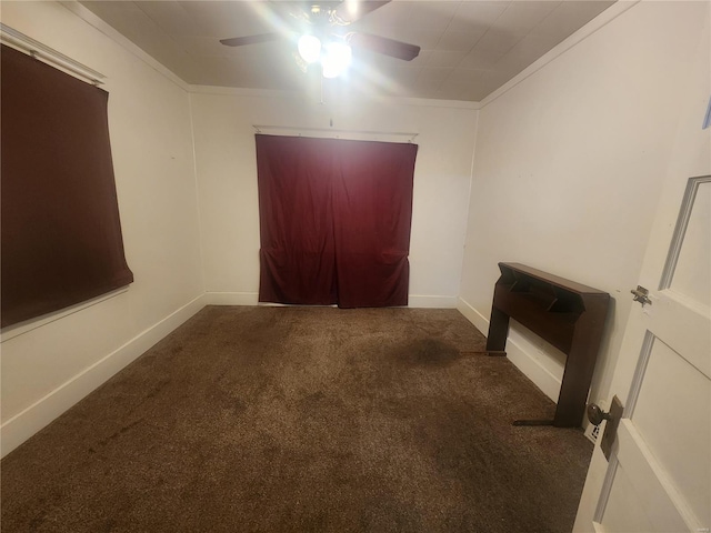 carpeted spare room featuring ceiling fan and crown molding