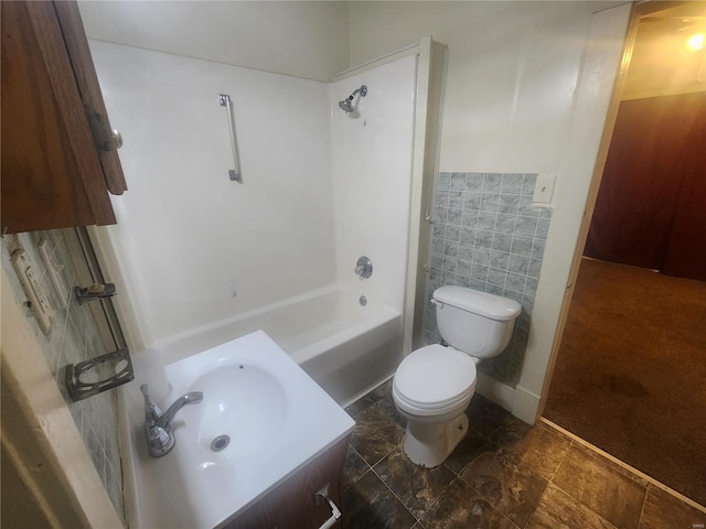 full bathroom with vanity, toilet, shower / washtub combination, and tile walls