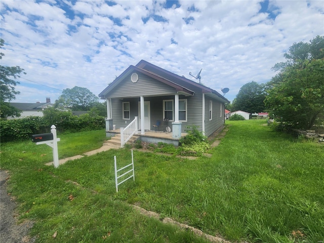 bungalow-style home featuring covered porch and a front lawn